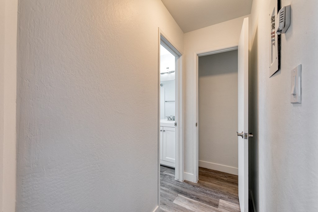 a bedroom with a medium sized window and a door that leads to a bathroom