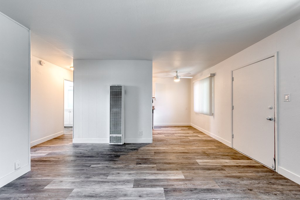 a bedroom with hardwood floors and white walls