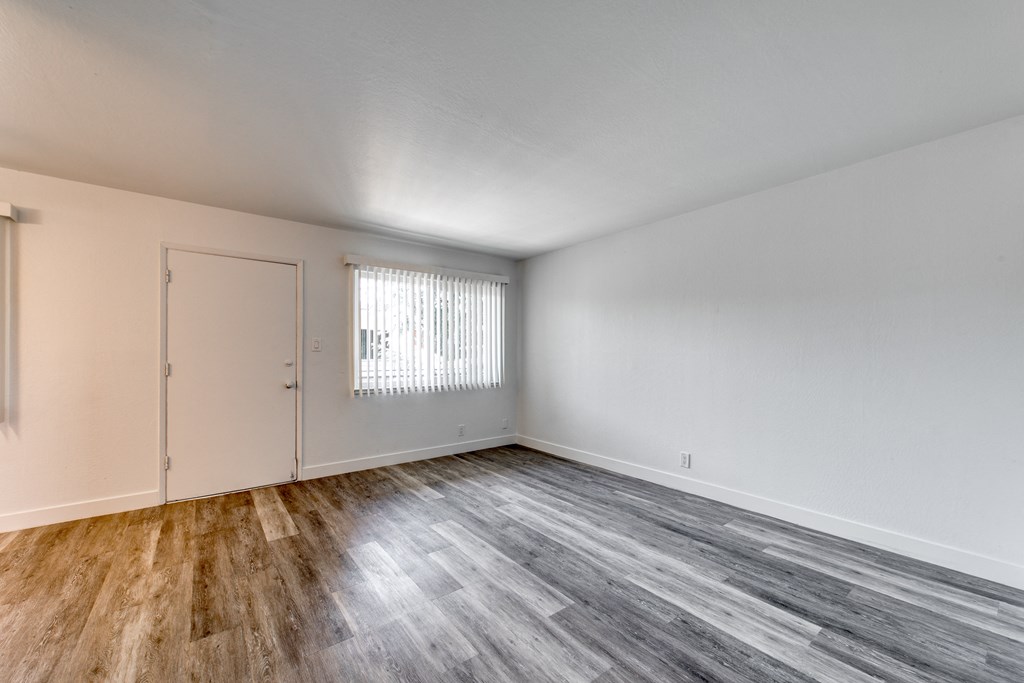 a bedroom with hardwood floors and white walls