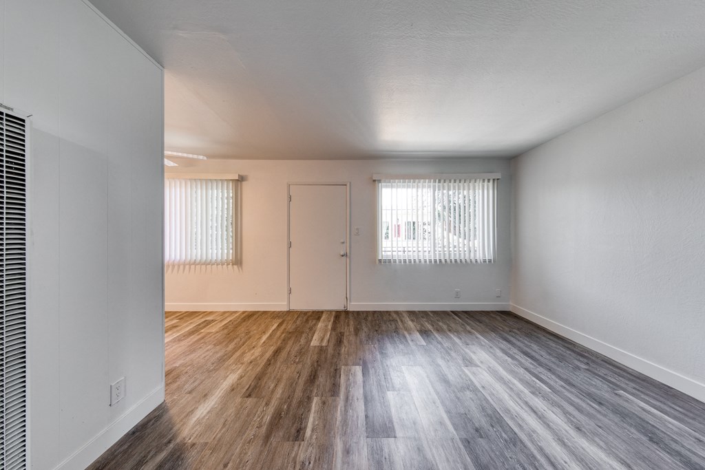 a bedroom with hardwood floors and white walls