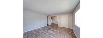 A room with wooden flooring and white walls.