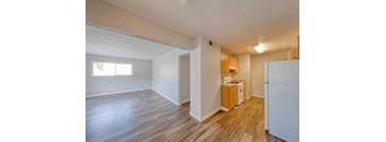 A kitchen area with a refrigerator, sink, and cabinets.