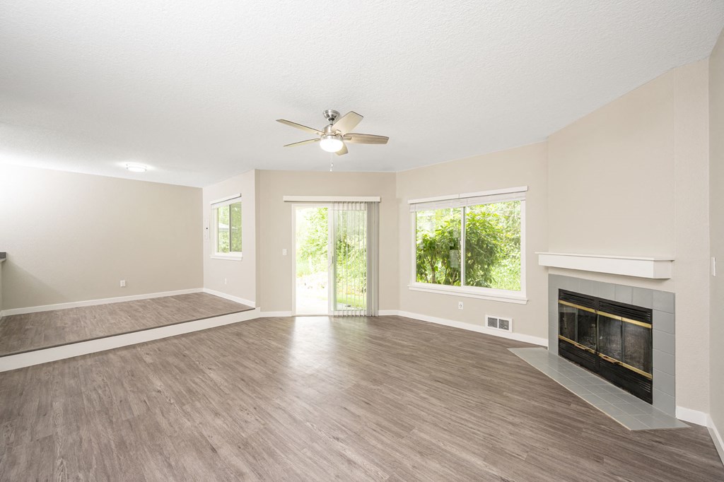 a living room with a fireplace and a ceiling fan