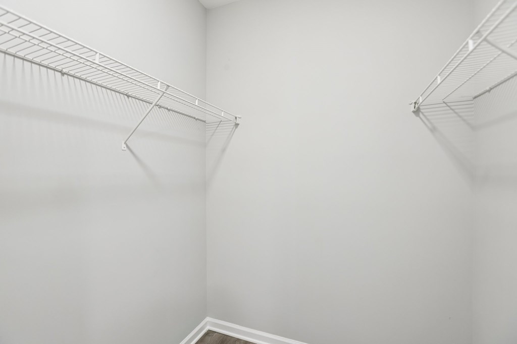 A white empty room with a metal rack on the wall.