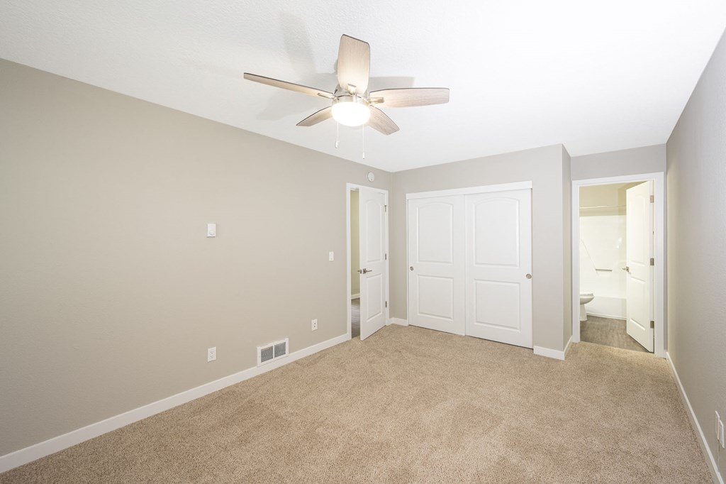 a bedroom with a ceiling fan and carpet