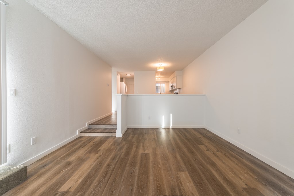 a bedroom with hardwood floors and white walls