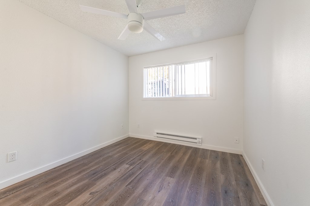 a bedroom with hardwood floors and a ceiling fan