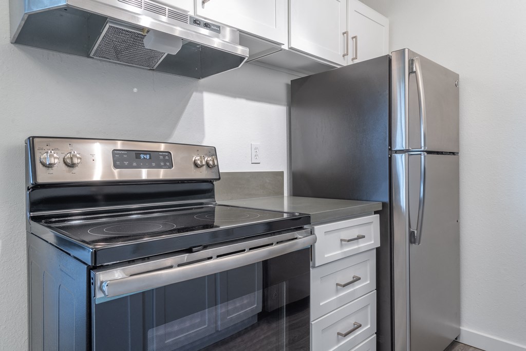 a kitchen with white cabinets and black appliances