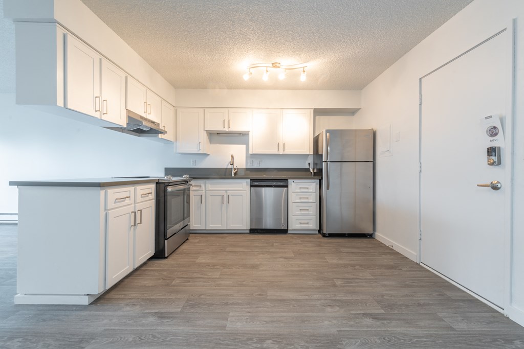 a kitchen with white cabinets and a wood floor