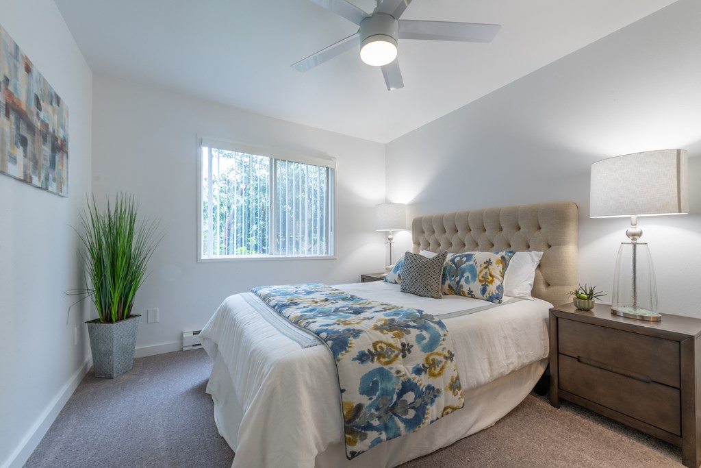 a bedroom with a large bed and a ceiling fan