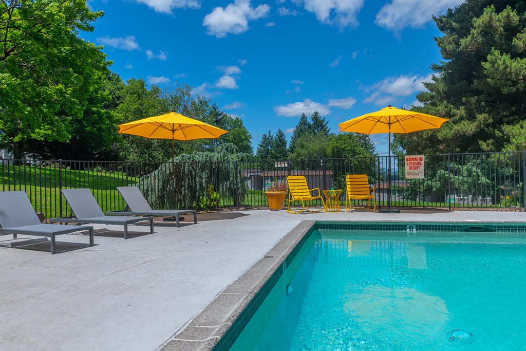 a swimming pool with yellow umbrellas