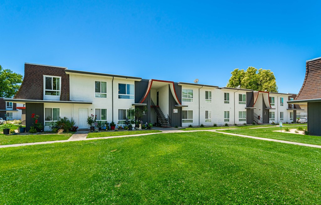 a row of houses with a green lawn in front of them