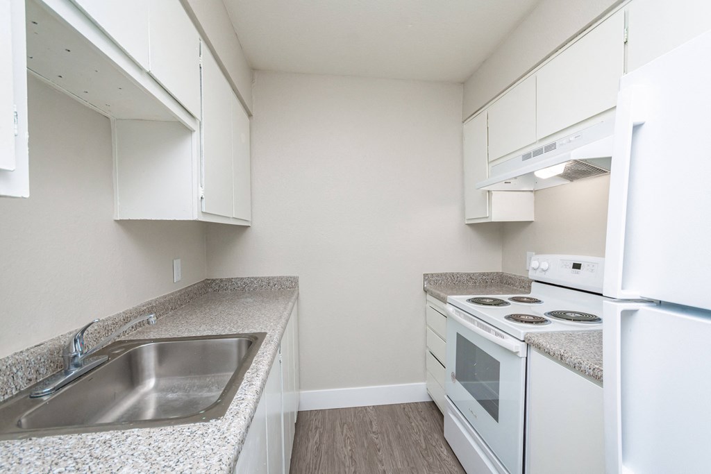 a kitchen with white appliances and granite countertops
