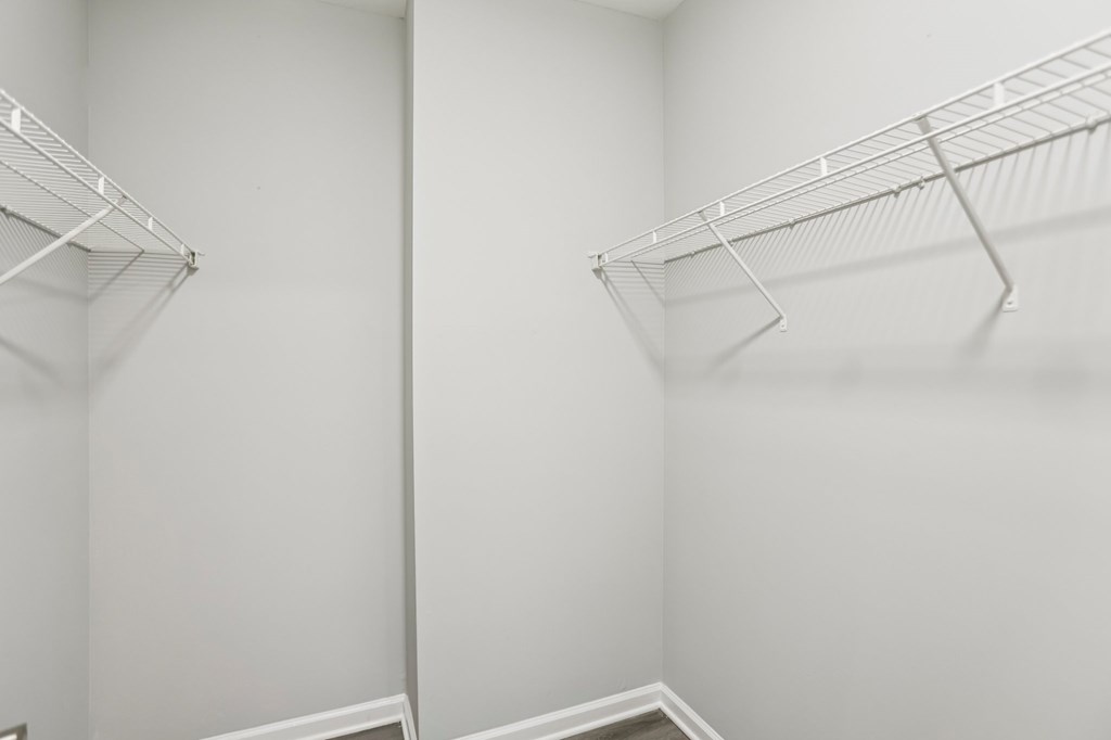 Two empty wire shelves in a white room.
