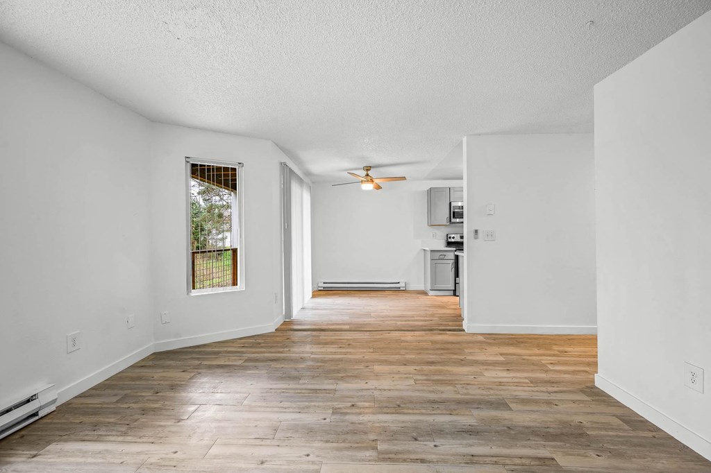 a renovated living room with hardwood floors and white walls