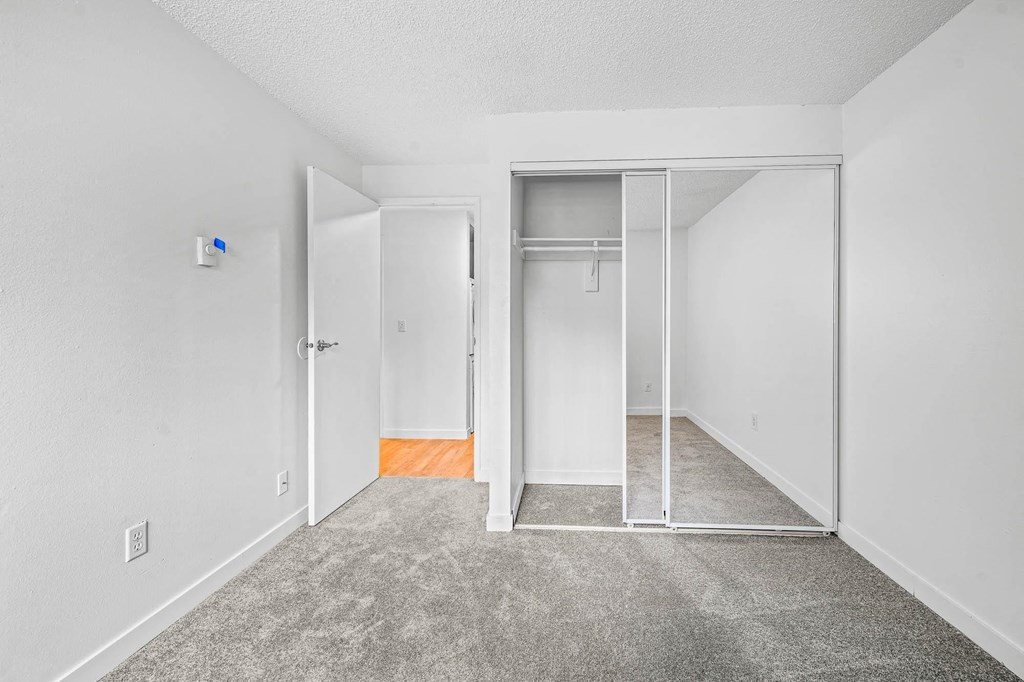 a bedroom with white walls and carpet