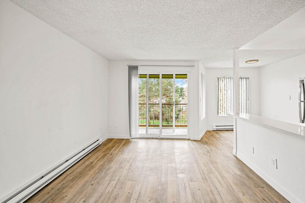 a bedroom with hardwood floors and white walls