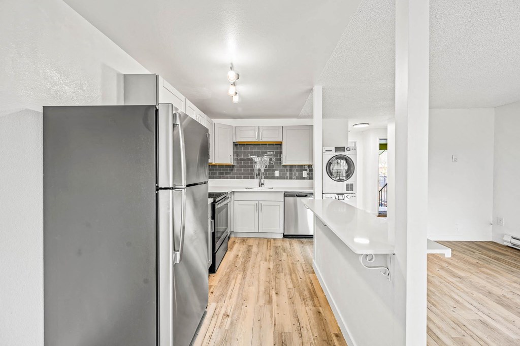 a kitchen with white cabinets and a wooden floor