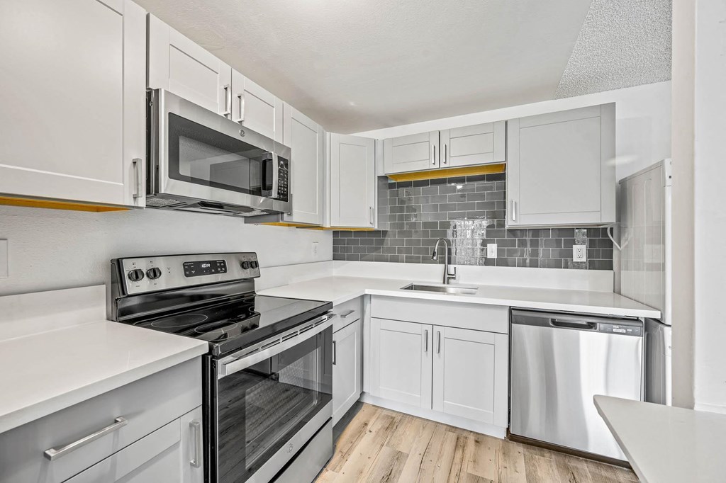 a kitchen with white cabinets and stainless steel appliances