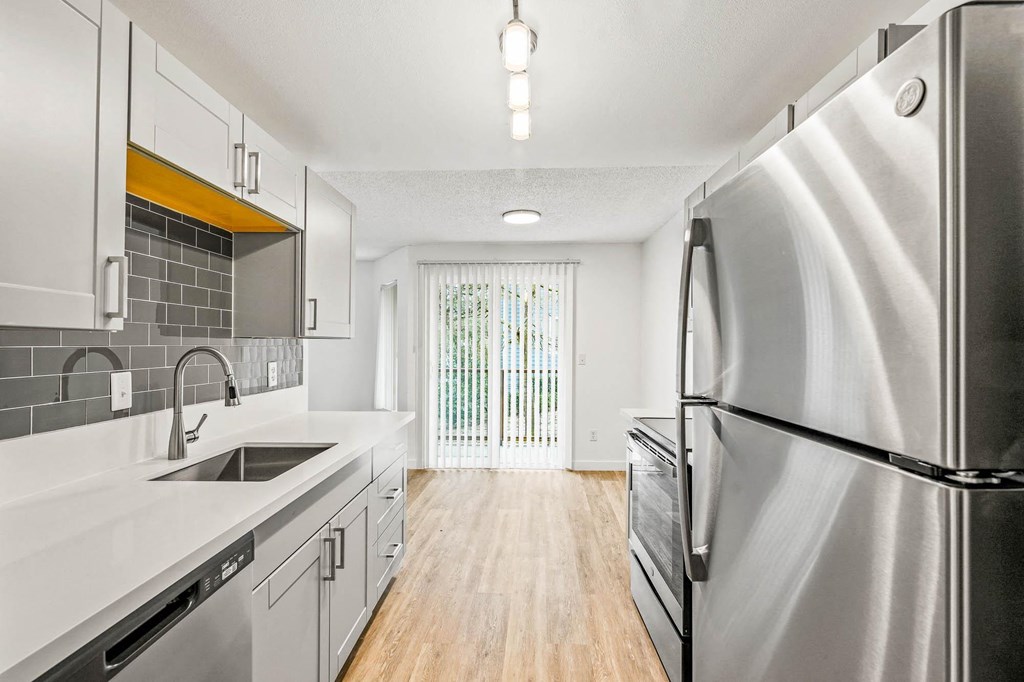 a kitchen with white cabinets and stainless steel appliances