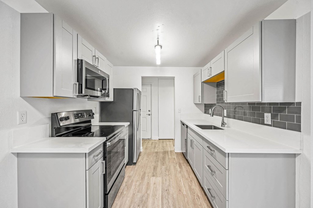 a kitchen with white cabinets and stainless steel appliances