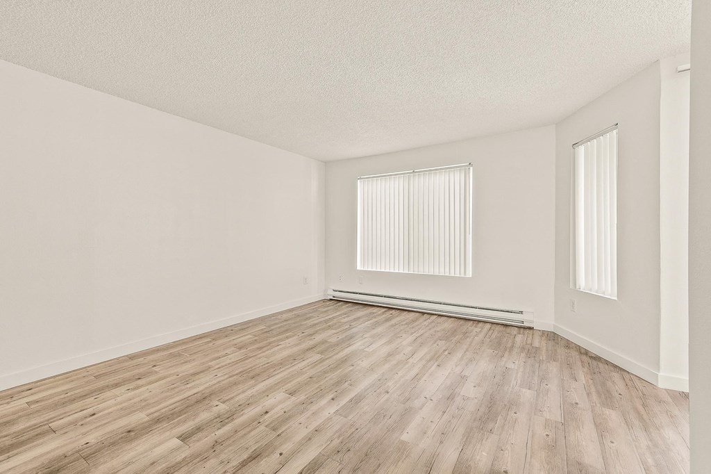 a bedroom with hardwood floors and white walls