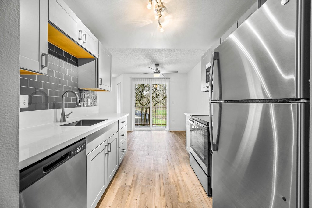a kitchen with white cabinets and stainless steel appliances