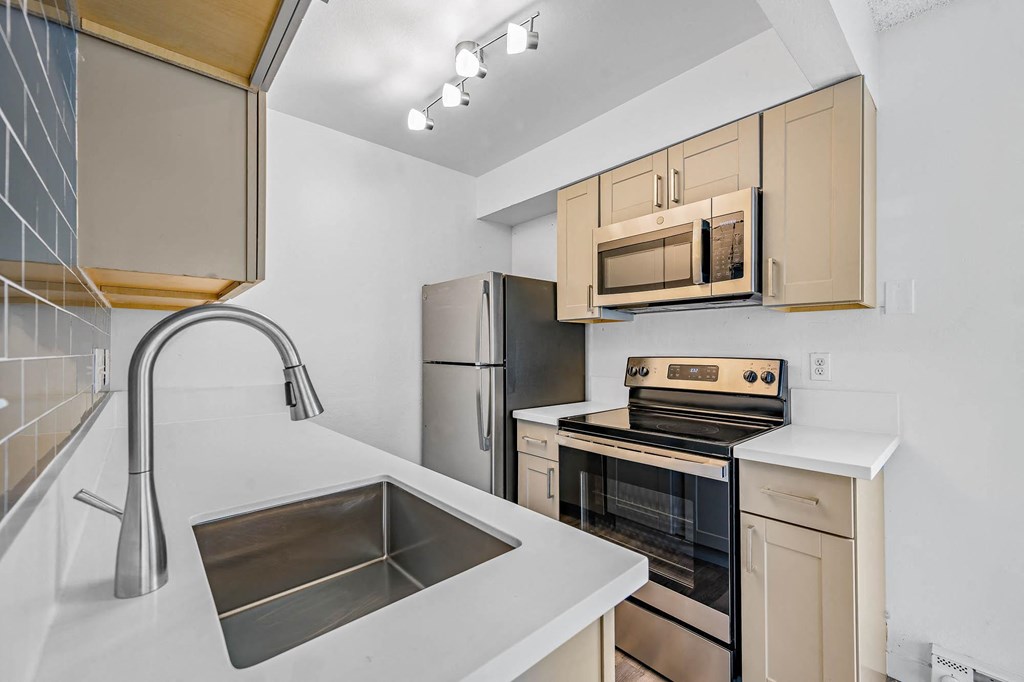 a kitchen with wood cabinets and stainless steel appliances