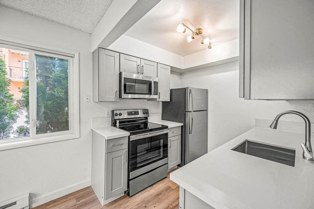 a kitchen with a stove top oven next to a window