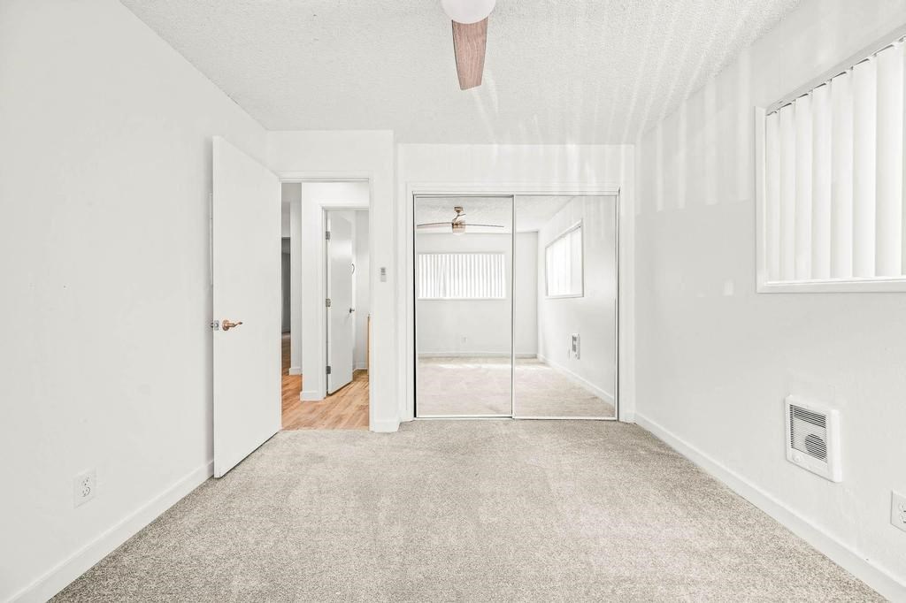 a bedroom with a bed and a ceiling fan