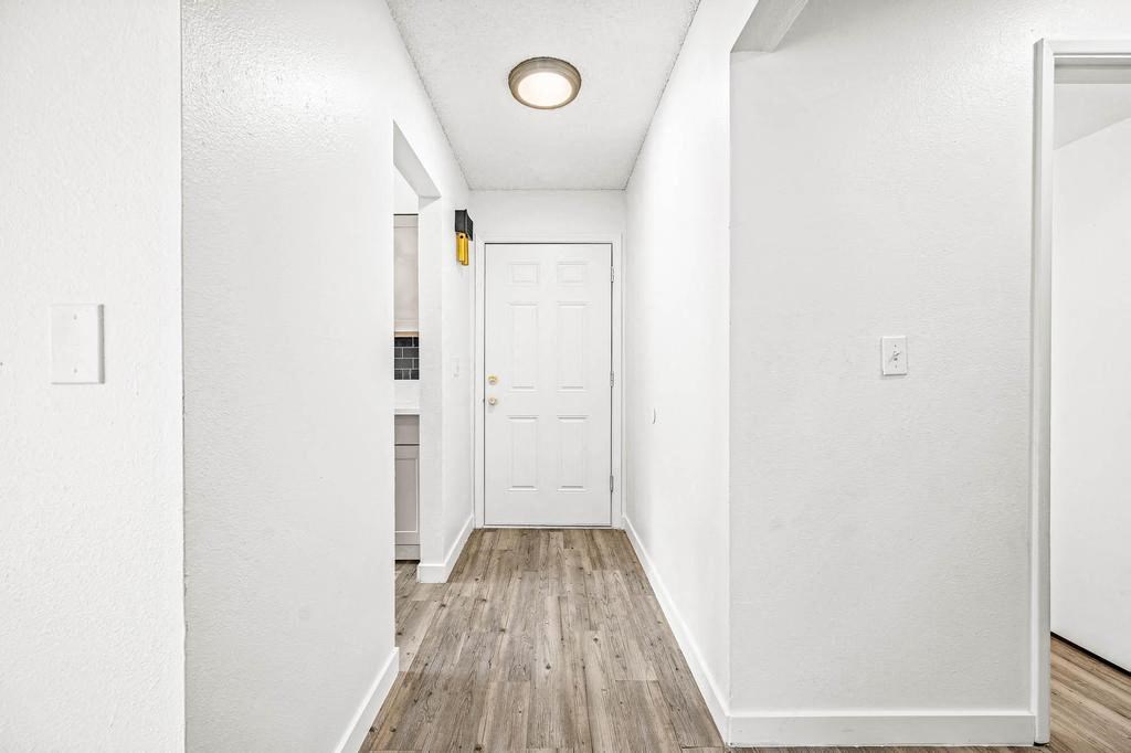 a hallway with a white door and white walls
