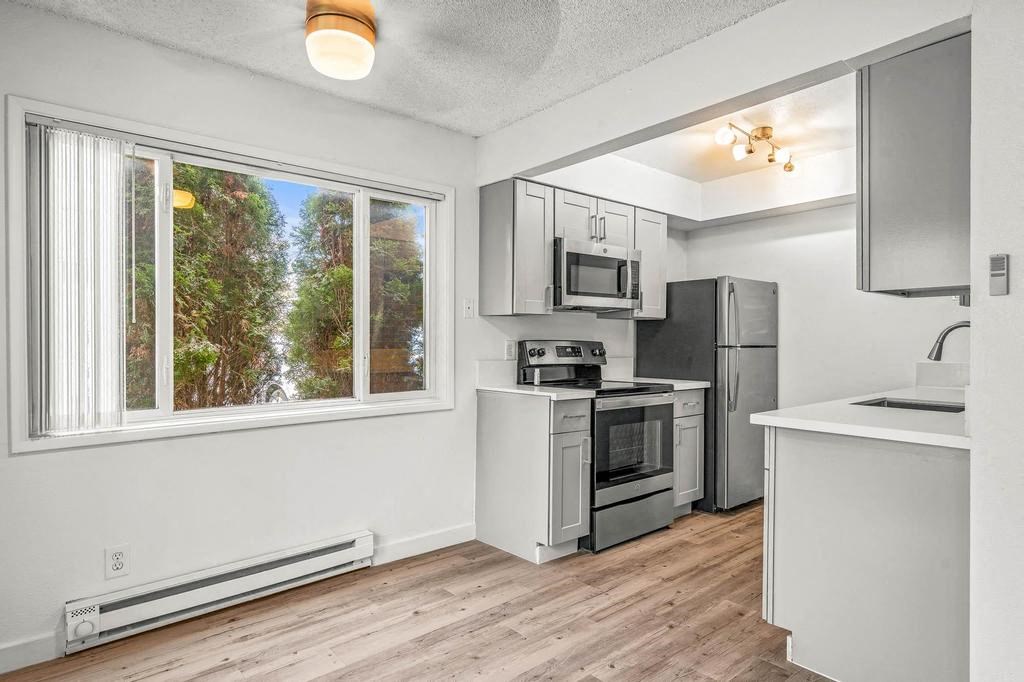 a kitchen with a stove top oven next to a window