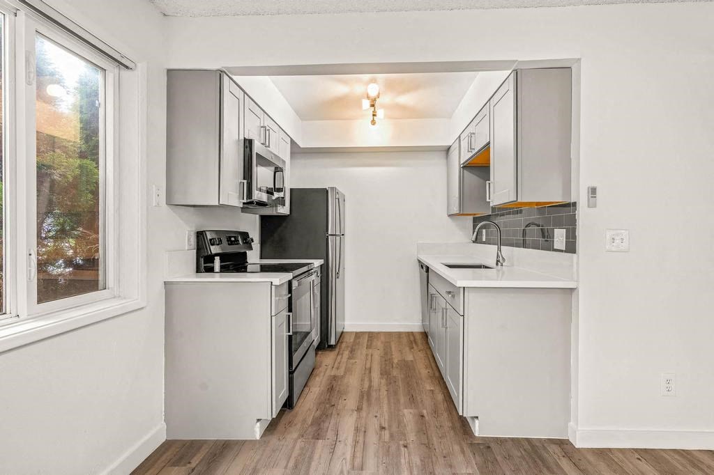 a kitchen with a stove top oven next to a window