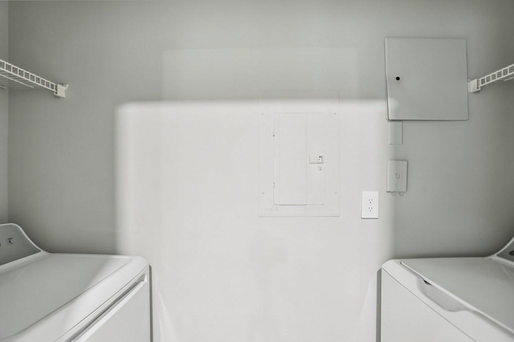 A white washing machine sits in a laundry room.