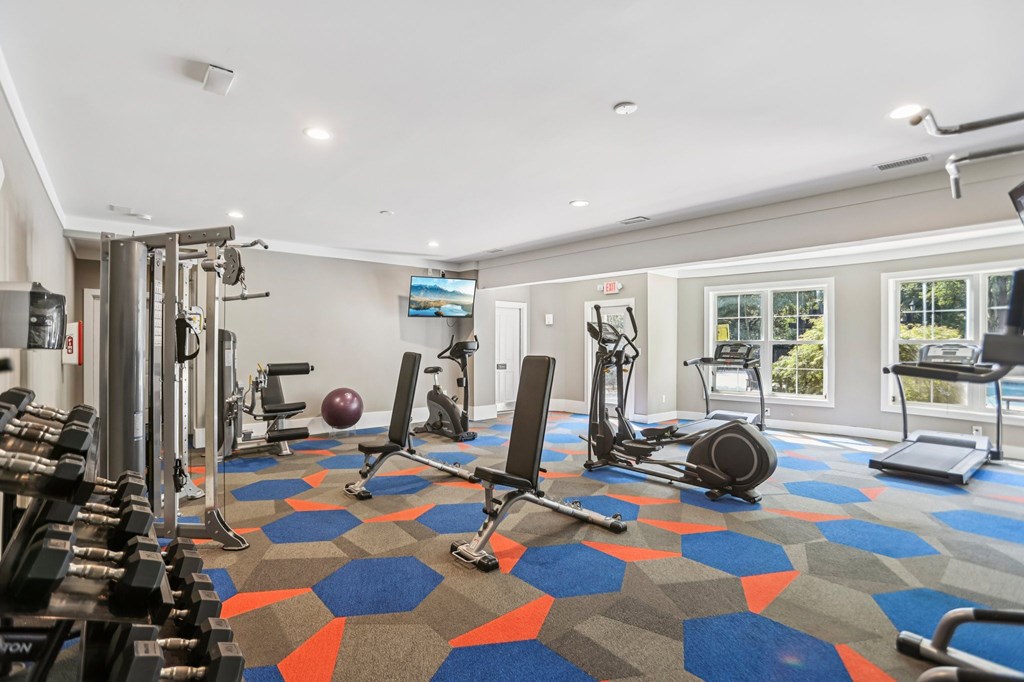 A gym with a variety of equipment including weights, a treadmill, and a stationary bike.