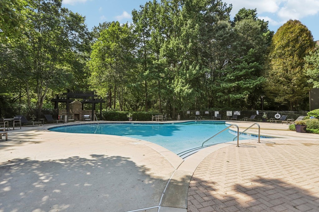 A large outdoor swimming pool surrounded by trees.