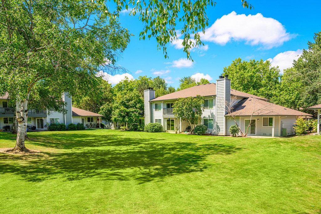 a large grassy area with houses in the background