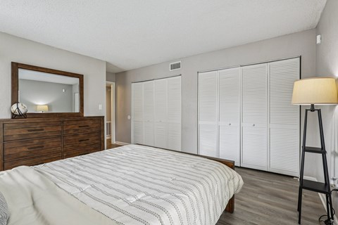 A bedroom with a bed, dresser, and mirror.