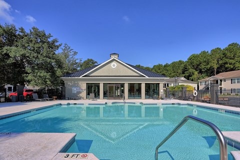 a swimming pool with a house in the background