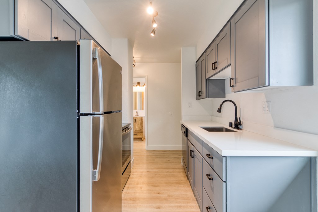 a kitchen with white countertops and gray cabinets