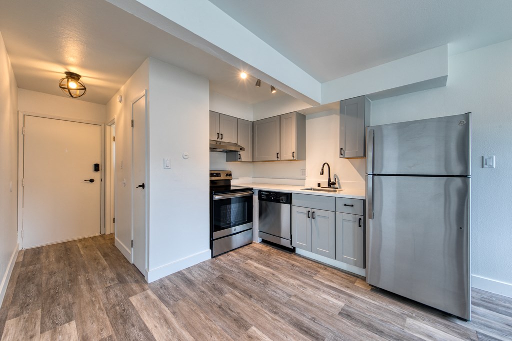 a kitchen with white cabinets and stainless steel appliances