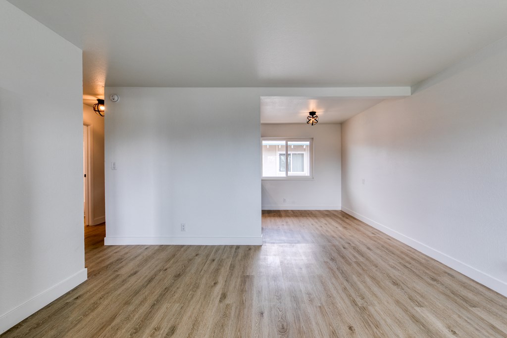 a bedroom with hardwood floors and white walls