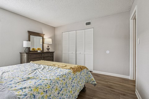 A bedroom with a bed, dresser, and wardrobe.