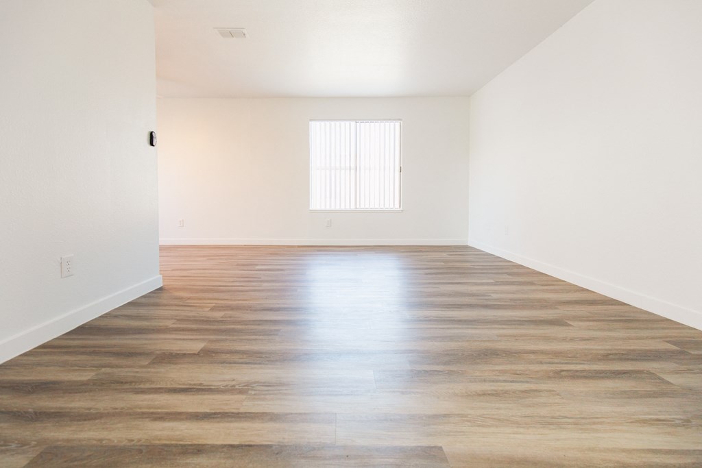 a bedroom with hardwood floors and white walls