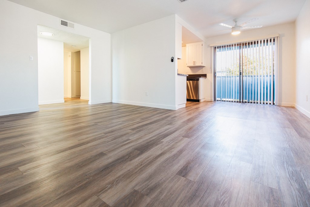 a living room with hardwood floors and a sliding glass door to a balcony