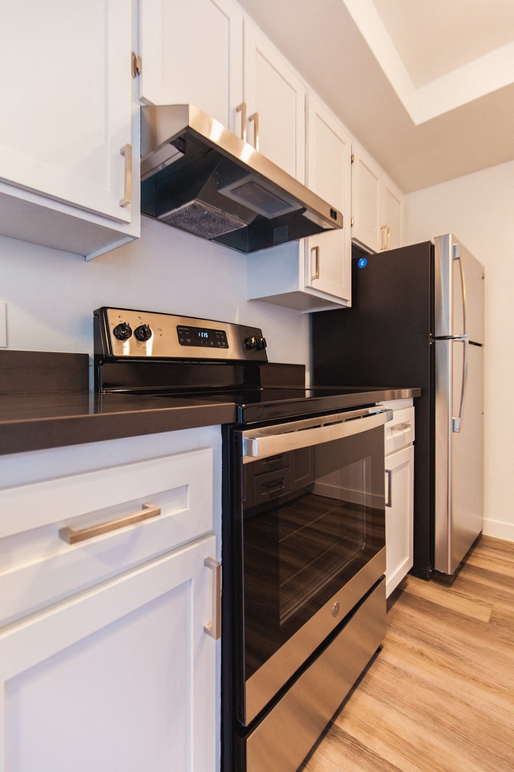 a kitchen with white cabinets and black appliances