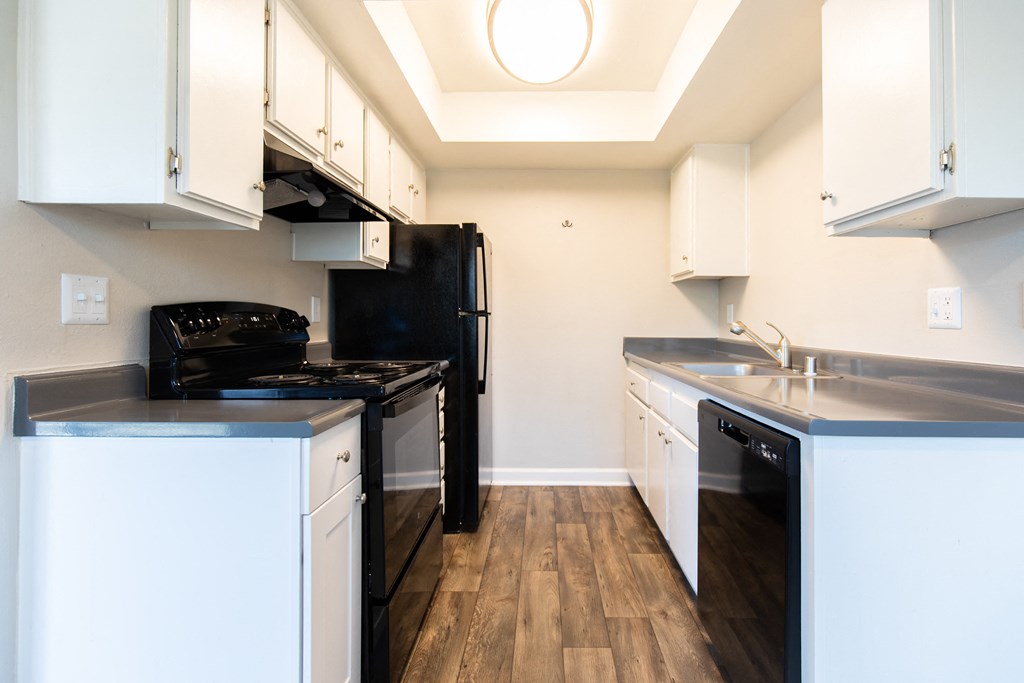a kitchen with white cabinetry and black appliances