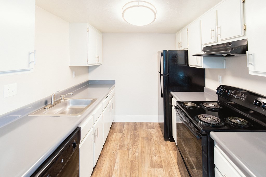 a kitchen with white cabinets and black appliances