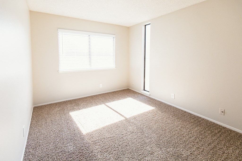 an empty room with a window and a door