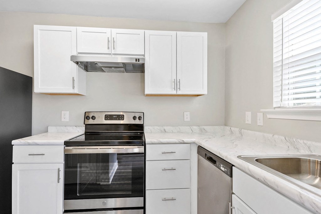a kitchen with white cabinets and stainless steel appliances